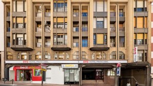 A multi-story hotel with balconies, a fitness club, and a market. - OYO Hotel Francabel (Cuenca)