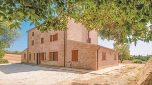 Un bâtiment de deux étages en briques, doté d’un toit plat, de nombreuses fenêtres et d’une allée pavée.