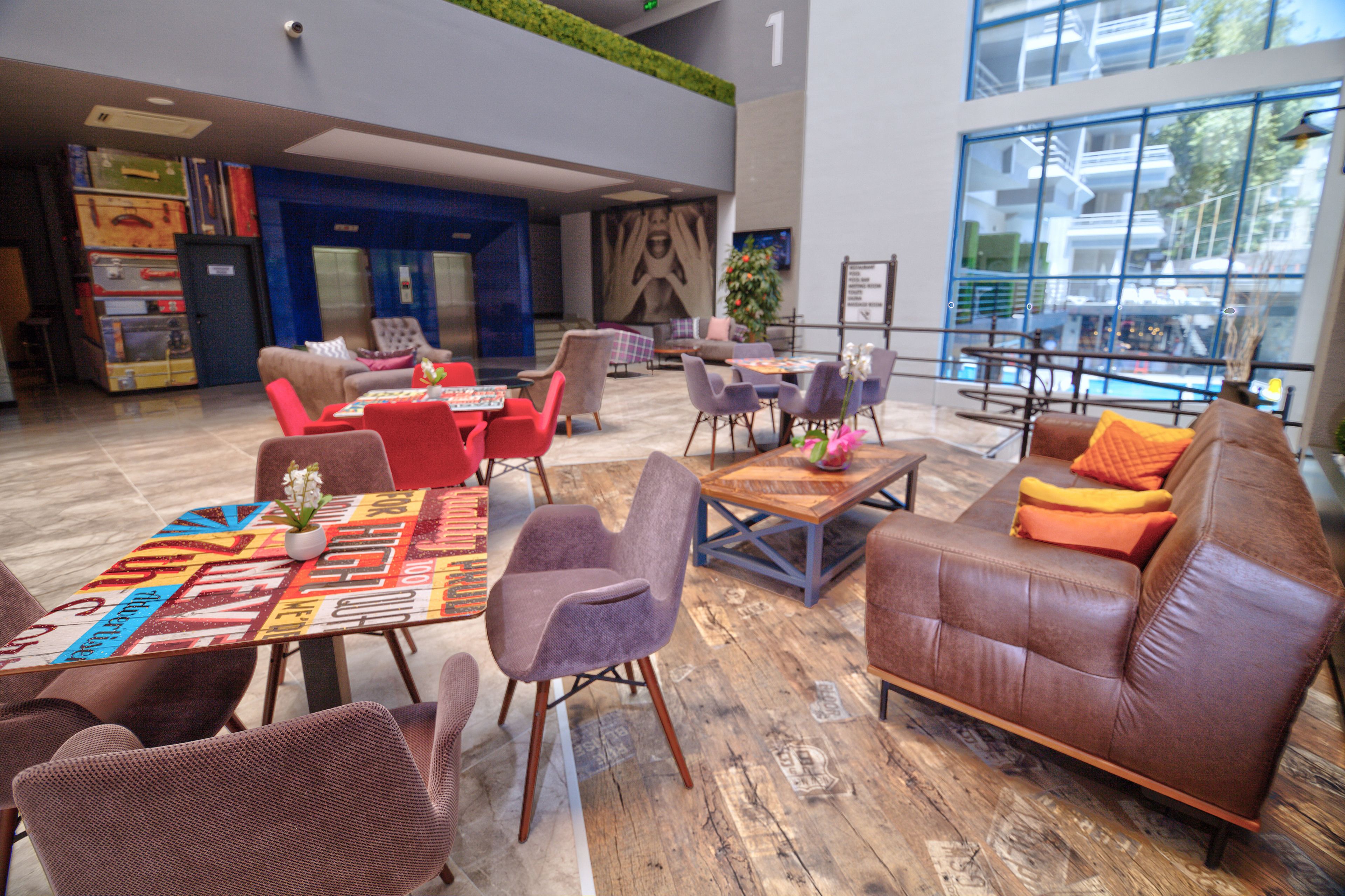 A spacious lobby with a variety of seating options, including sofas and chairs, arranged around a central coffee table.