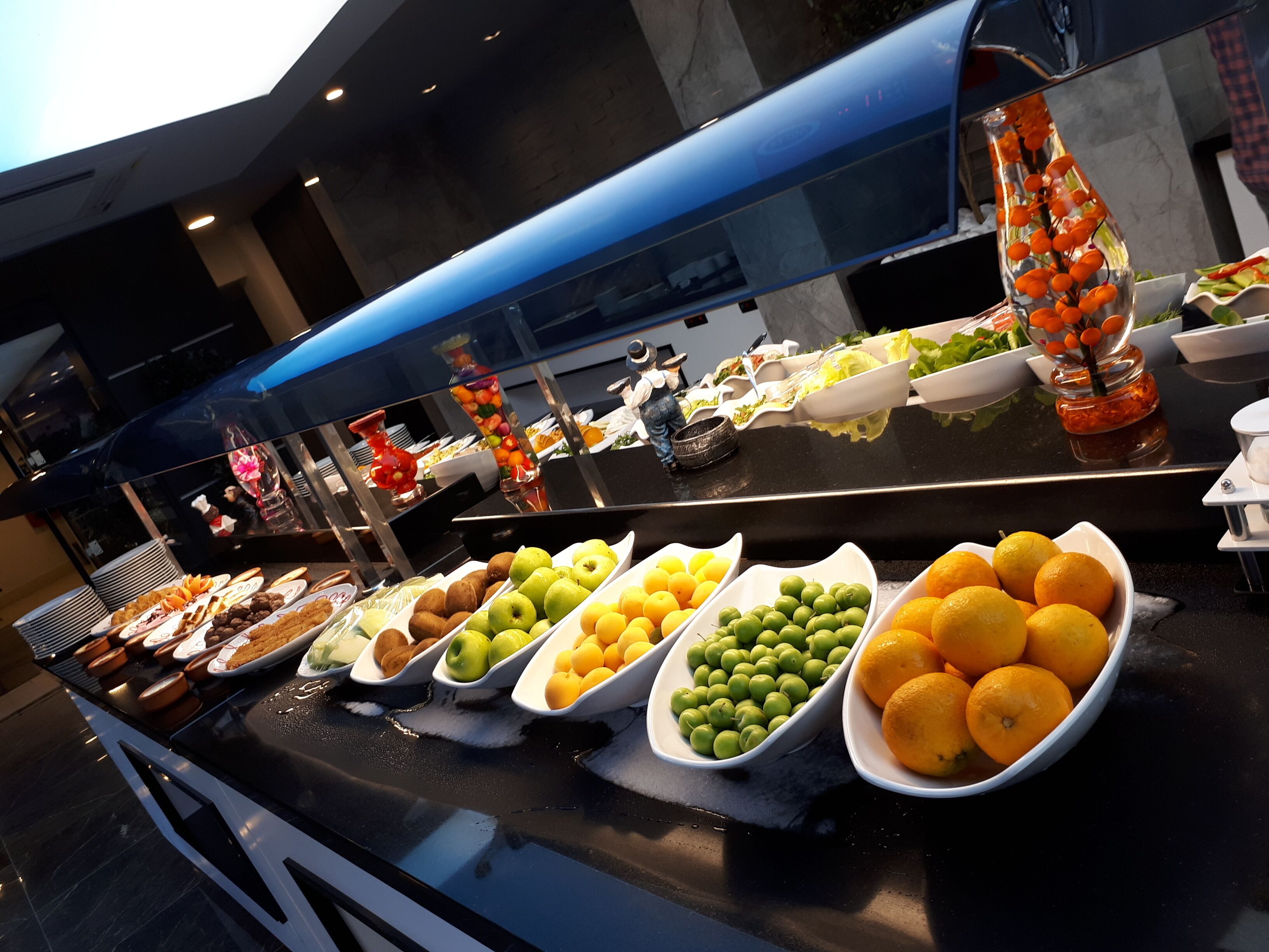 A buffet with various fruits and dishes.