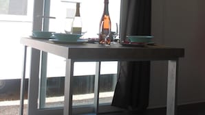 A modern kitchen with a large window, a table with dishes, and a bottle. - Agriturismo il giardino degli ulivi (Cortona)