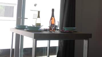 Una cucina moderna con un'ampia finestra, un tavolo apparecchiato e una bottiglia.