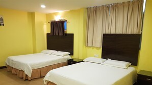 Habitación de hotel con dos camas, una mesita de noche, una ventana con cortinas y un aire acondicionado instalado en la pared.
