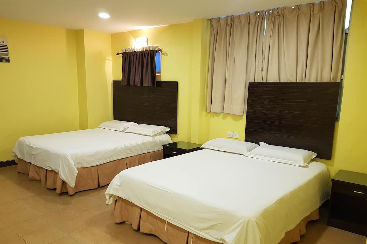 A hotel room with two beds, a nightstand, a window with curtains, and a wall-mounted air conditioning unit.