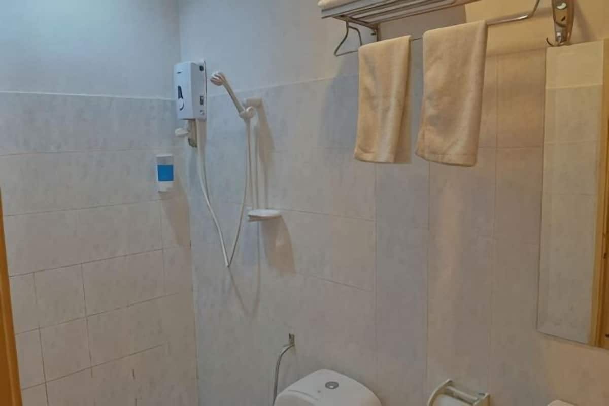 A bathroom with a shower, toilet, and towel rack.