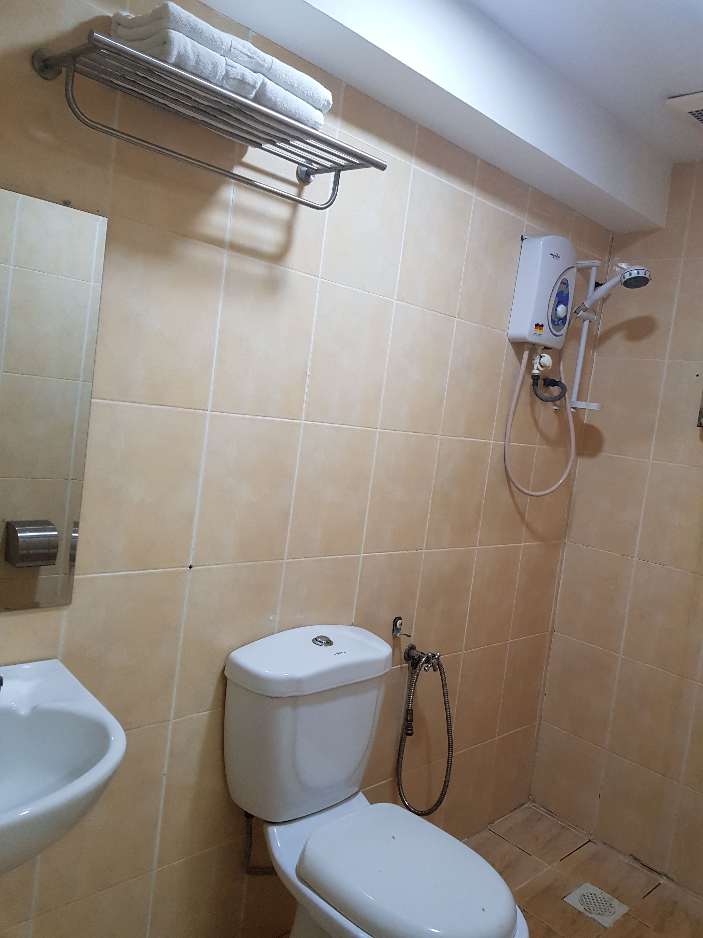 Un baño con inodoro, bidé y un perchero para toallas.
