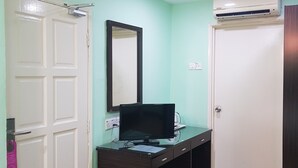 Una habitación con un escritorio, una computadora, un espejo y un equipo de aire acondicionado.
