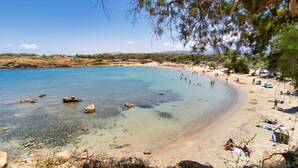 A beach with clear water, rocks, and people. - Zinovia (Chania)