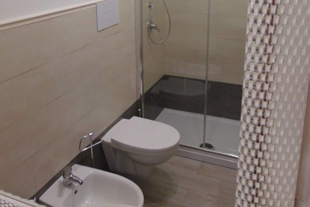 Une salle de bain avec douche, toilettes et lavabo.