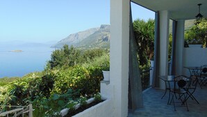 A terrace with a view of the sea and mountains, featuring outdoor furniture and potted plants. - Vista Mare Maratea B&B (Maratea)