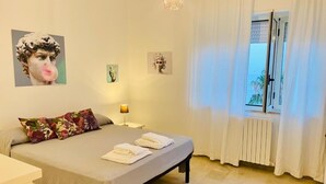 A bedroom with a bed, pillows, a nightstand, a lamp, and artwork on the walls. - Vista Mare Maratea B&B (Maratea)