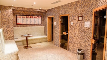 Zona de spa con paredes de mosaico, un mostrador de recepción y una sala de estar.