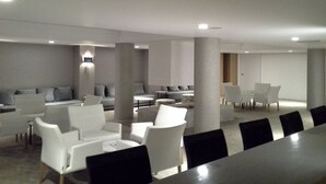 A modern conference room with white and black chairs, a long table, and grey sofas. - Edirne Park Hotel (Edirne)