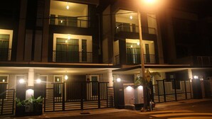 A multi-story building with balconies and a gated entrance. - Balinese House (Malacca City)