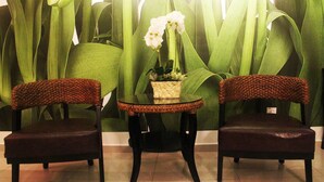 Two chairs with woven backs and a small glass table with a potted plant between them. - Balinese House (Malacca City)