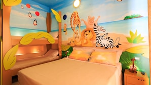 Habitación infantil con un mural de playa, camas literas y una mesita de noche con un adorno de pingüino.