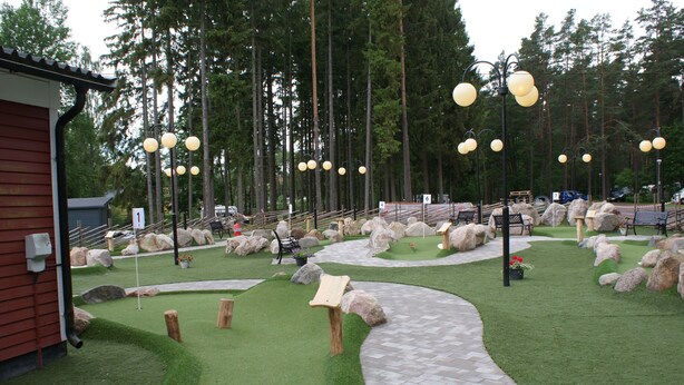A landscaped garden with a winding path, benches, and large rocks.