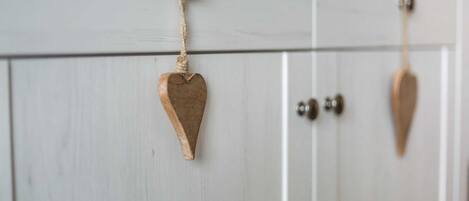 A white wooden door with a heart-shaped decoration hanging from a hook.