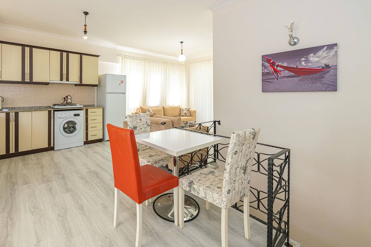 A compact living space with a kitchen, dining area, and a sofa.