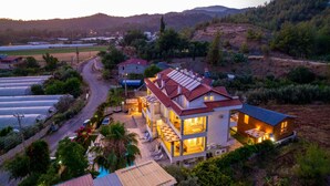 A two-story house with a red roof, a balcony, and a swimming pool. - Anatolian Apartments (Fethiye)