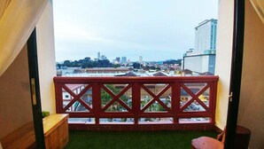 A balcony with a red railing, a small wooden bench, and a trash bin. - Urban Industrial City View (Malacca City)