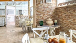 A breakfast setup with a table, chairs, and a view of the kitchen area. - 2 bedroom stunning apartment in Grottaglie (TA) (Grottaglie (TA))