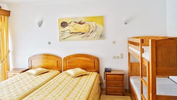 Un dormitorio con dos camas de madera, una mesita de noche, una cama litera y un cuadro en la pared.