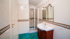 A bathroom with a shower, a sink, and a mirror. - Il Roseto (Ravello)
