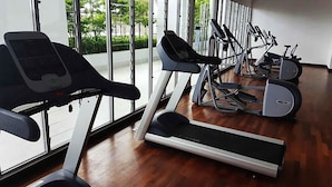 Un gimnasio con cintas de correr, bicicletas estáticas y equipo de ejercicio.