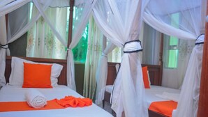A room with a bed, a rolled towel, and an orange cloth. - Suswa Six Apartment (Mombasa)