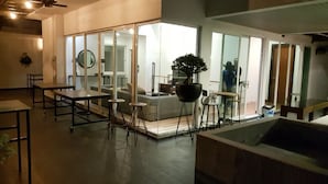 A modern living room with a large sliding glass door leading to a balcony, a large potted plant, and a seating area with a sofa and chairs. - La Maison 100 (Kuala Lumpur)