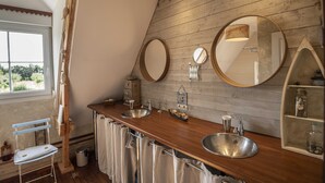 Un baño con paredes de madera, dos lavamanos y un espejo.