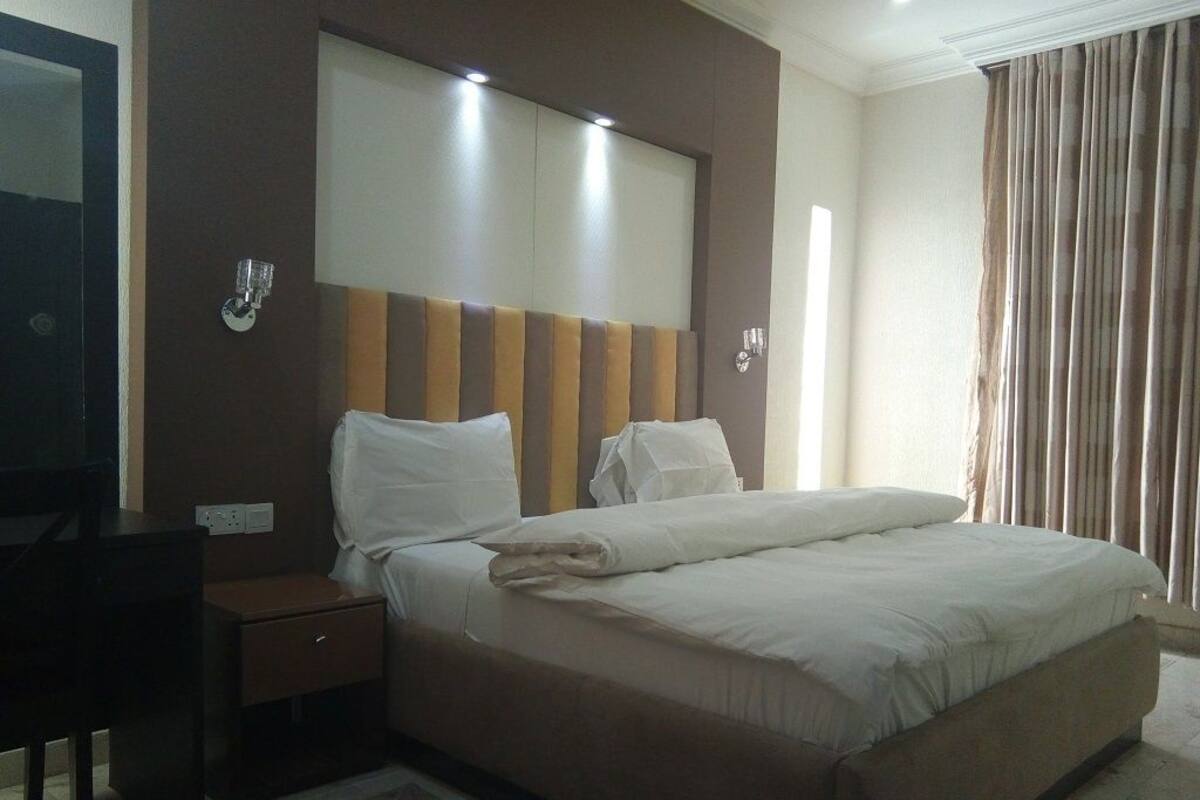 Ein Hotelzimmer mit einem großen Bett, einem Schreibtisch und einem Spiegel.