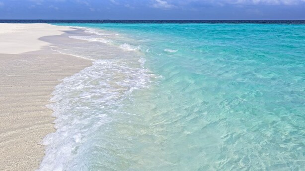 A beach with clear turquoise water and white sand.