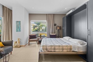 Living Room - features a double-size Murphy bed that folds away effortlessly to maximize space, sliding doors for added privacy when used as a second bedroom, and a cozy private balcony with charming street views.
