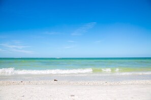 A beach with clear turquoise water and a white sandy shore. - 1 Bedroom / New Furniture / Direct beach access / Across from J.W. Marriott! (Marco Island)