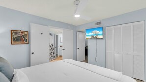 A bedroom with a bed, a ceiling fan, a TV on the wall, and a closet. - 1 Bedroom / New Furniture / Direct beach access / Across from J.W. Marriott! (Marco Island)