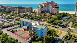 A high-rise hotel with multiple floors, a swimming pool, and a tennis court. - 1 Bedroom / New Furniture / Direct beach access / Across from J.W. Marriott! (Marco Island)
