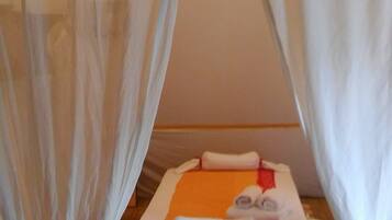 Relax in a serene space with a comfortable bed and a canopy.