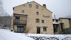 A two-story building with the name "Ouellet's" on the side. - Hotel Cruells (Planoles)