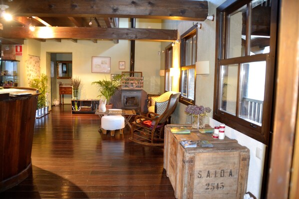A cozy room with wooden floors, a rocking chair, a wooden chest, and a large window.