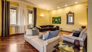 A living room with two sofas, a coffee table, and a painting on the wall.