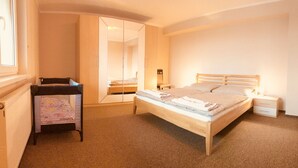 Un dormitorio con cama, mesita de noche, armario y espejo.