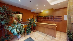 Cocina moderna con armarios de madera, una isla central y diversas plantas en macetas.