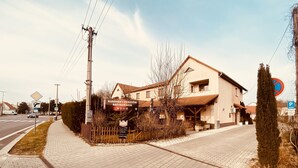 Un edificio con un letrero del Restaurante Pensión Rusovsky, una acera pavimentada y un letrero de no estacionamiento.