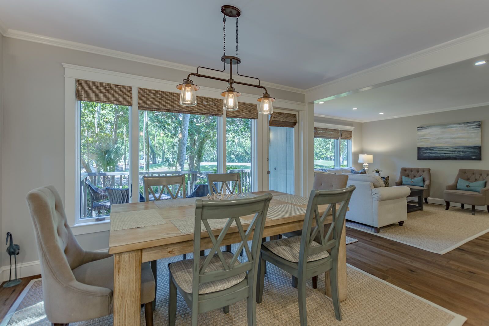 A dining area with a wooden table, four chairs, and a hanging light fixture.