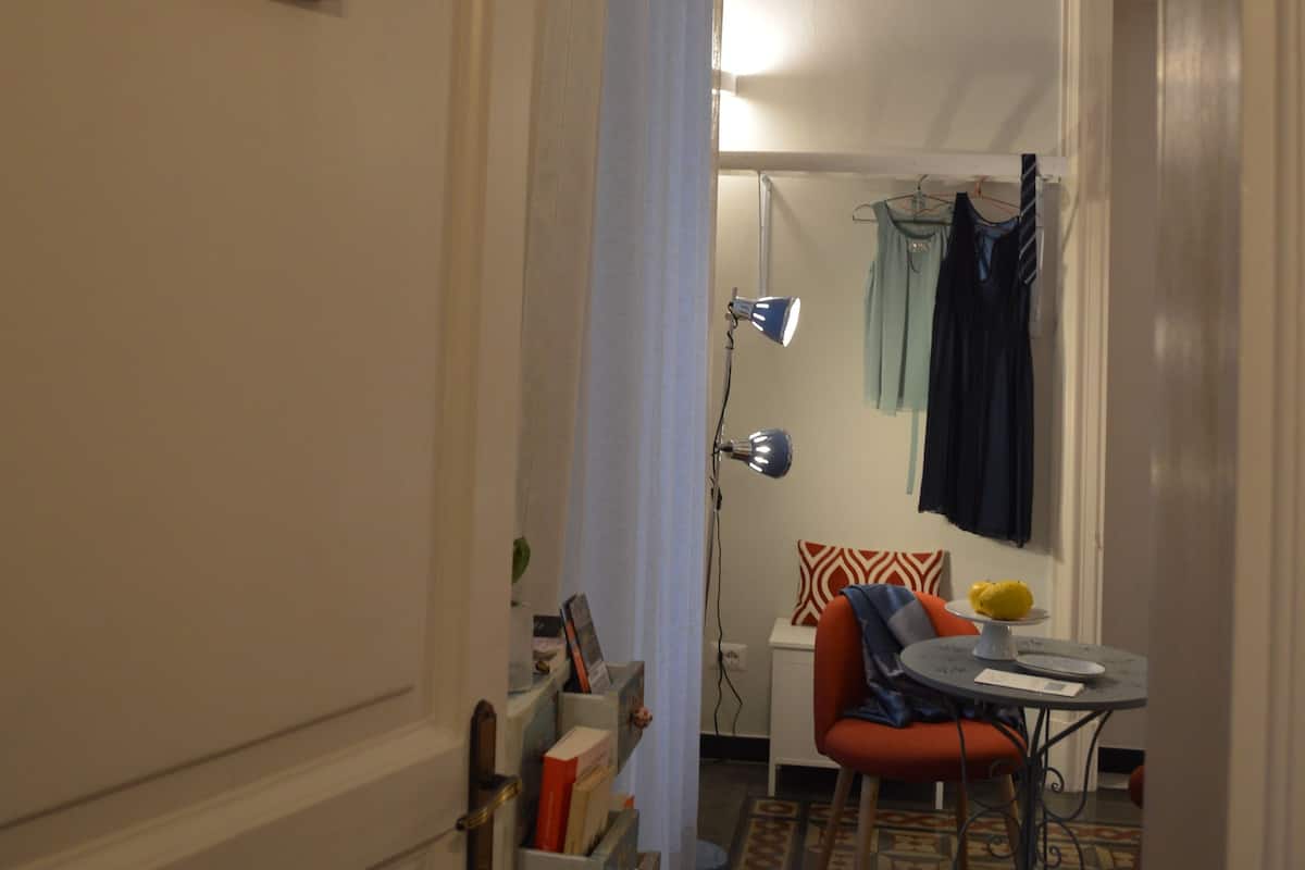 A hallway with a door labeled "Stanza Bronte," a small table with a lamp, a chair, and a patterned rug.