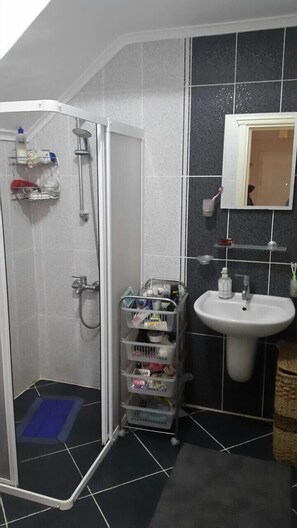 Tweepersoonskamer | Badkamer | Een douche, een haardroger, handdoeken