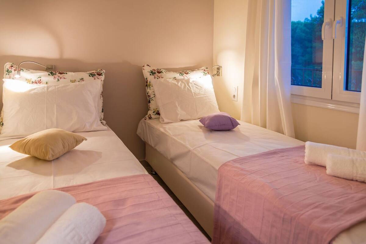 A bedroom with two beds, each with a floral pillow and a white blanket.