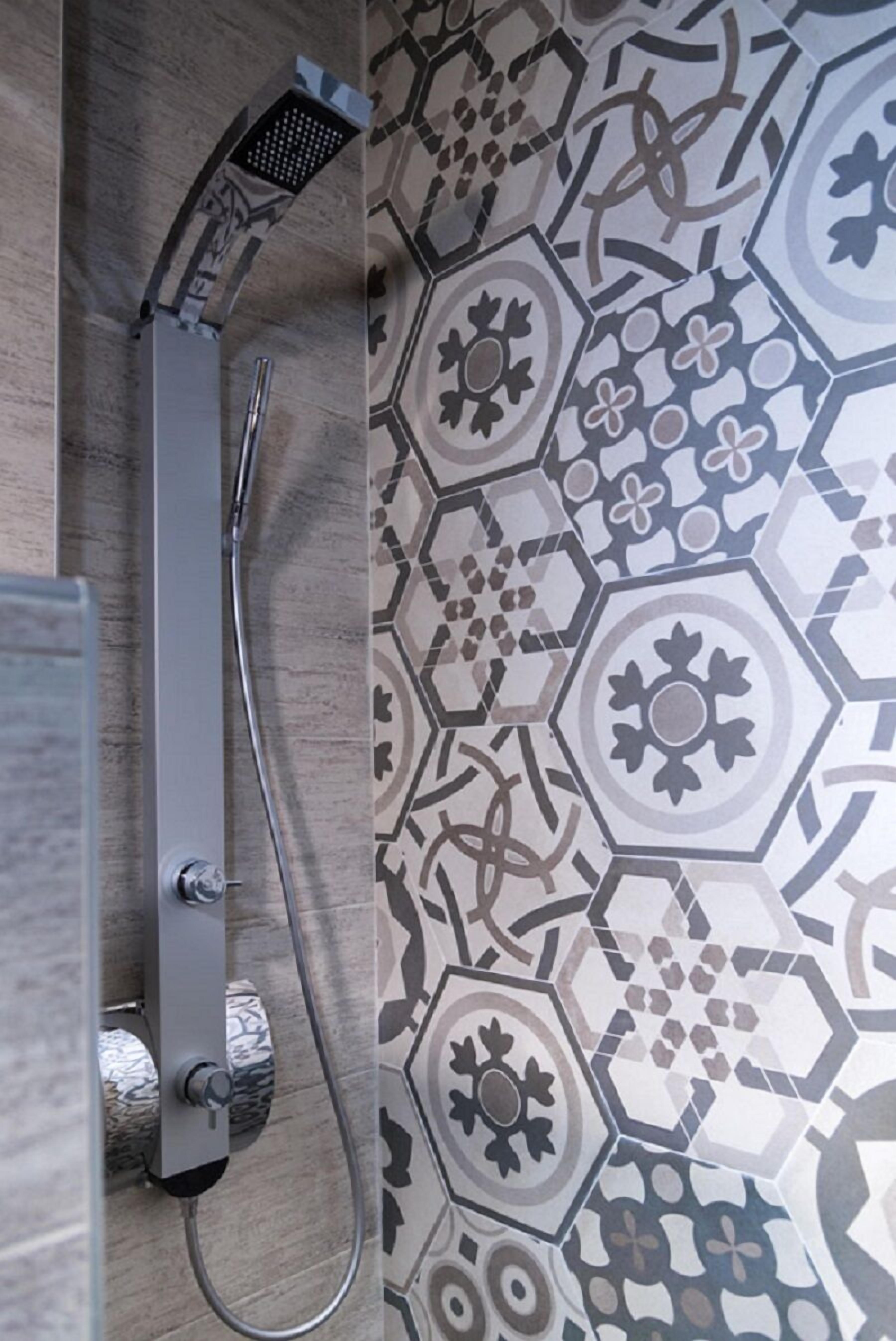 A shower with a modern design, a tiled wall with a geometric pattern, and a visible shower control panel.